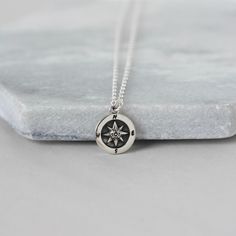 This minimalist charm necklace features a beautifully detailed compass charm. The one-sided charm shows a nautical star with etched letters for North, South, East and West. The 11mm compass is made from sterling silver and it has an oxidized background and letters to highlight the details and provide a nice contrast. The charm hangs from sturdy sterling silver cable chain and the necklace looks stylish on its own or layered with others. The necklace is fastened with a sterling silver spring ring Silver Compass Necklace, Compass Necklace Silver, Minimalist Jewelry Silver, Nautical Star, Gift For Graduation, Necklace Everyday, Compass Necklace, Gold Charm Necklace, North South