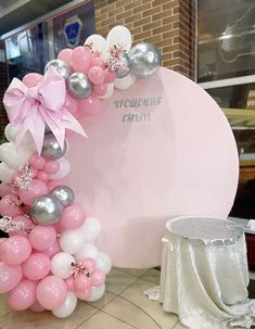 a balloon arch with pink and silver balloons