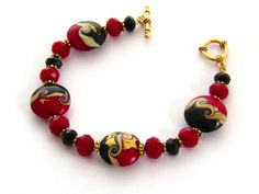 "Red Bracelet, Lampwork Artesian Glass Bracelet, Gold Black and Red Bracelet, Jewelry Gift for Her 8.25 inch Hand made beaded red, black, and gold  - red lampwork glass bracelet. I used gold foiled artisan lampwork beads coupled with large cool red Czech crystals and black Czech crystals, interspersed with tiny gold beads. The bracelet closes with an easy-to-use gold plated toggle clasp with a rope motif. Length: 8.25 inches Please leave a note if you need a slight adjustment in length. Arrives with a Marty White card in a lovely decorative bag and bubble wrap packaging. Follow me on Facebook: http://www.facebook.com/pages/Marty-whitedesigns/159425327440004 ** Please \"Favorite\" my shop and come back often! Thanks for buying hand-made...2017-57 Red Lampwork Bracelet/Red Lampwork Glass Bra Holiday Bracelet, Lampwork Bracelets, Holiday Bracelets, Art Glass Jewelry, Silver Locket Necklace, Red Beaded Bracelet, Red Bracelet, Lampwork Jewelry, Locket Bracelet