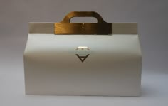 a white bag with a gold handle on it