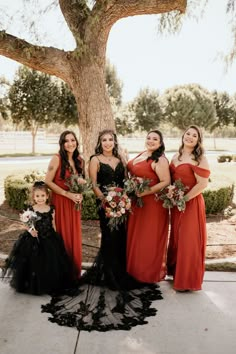 a group of women standing next to each other under a tree