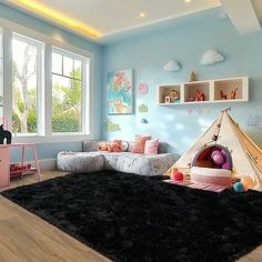 a child's room with blue walls and black rugs on the floor in front of a large window