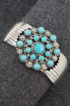 This stunning turquoise and bright-polish sterling silver bracelet was made by Navajo silversmith Jeremy Delgarito. The back is signed J Delgarito and stamped sterling.Size: 5 3/4" (will fit up to a 6 3/4" wrist)Gap: 1"Width: 1 5/8"Free shipping on all orders! We ship with USPS and always include tracking. All orders ship within a day of payment.Returns are accepted up to 30 days after you receive your order. Just send us a message. Our shop offers cash back or store credit. The item must be returned in new condition. Elegant Turquoise Concho Jewelry, Western Style Blue Sterling Silver Bracelet Gift, Collectible Bohemian Blue Sterling Silver Bracelet, Southwestern Style Round Turquoise Cuff Bracelet, Southwestern Style Turquoise Cuff Bracelet, Sterling Silver Turquoise Concho Jewelry, Southwestern Style Turquoise Bracelet Stamped 925, Western Style Blue Bangle Jewelry, Elegant Blue Jewelry With Concho Detail