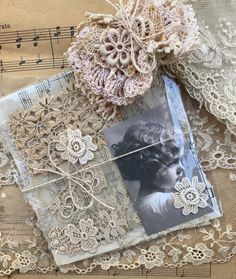 an old photo and some lace on top of sheet music