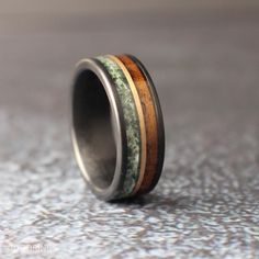 a wedding band with wood and moss inlays on the inside, sitting on a surface