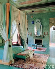 a bedroom with green walls and white drapes on the ceiling, an ornate canopy bed sits in front of a fireplace