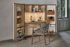 a chair sitting in front of a desk with an open bookcase on top of it