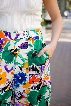 Get ready to light up the room with our Aurora Lights Pants! These high-waisted straight leg pants feature a vibrant and playful multi floral print in green, blue, purple, orange, and black hues. They feature an elastic waist at the back and square pockets that add comfort and functionality, making them the perfect addition to your spring and summer wardrobe. Pair with our Bristol Collared Tank to complete the look. They are lightweight, non-sheer, and fit true to size. 100% Polyester Brand- Ent Floral Print High-waisted Wide Leg Pants For Day Out, Colorful High-waist Bottoms For Spring, High Waist Colorful Bottoms For Spring, High-waisted Colorful Bottoms For Spring, Colorful Vibrant Bottoms For Spring, Vibrant Wide Leg Spring Pants, Vibrant Wide Leg Pants For Spring, Multicolor Floral Print Pants For Spring, Spring Green Wide Leg Pants With Floral Print