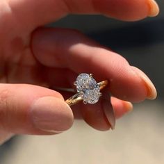 a person holding a diamond ring in their hand