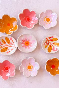 six flower shaped dishes sitting on top of a table