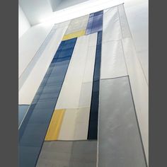 an abstract painting with blue, yellow and white stripes on it's side wall