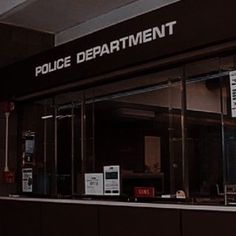 there is a police department sign on the wall in front of this building that says police department