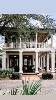 a large white house with lots of windows and balconies on the second story