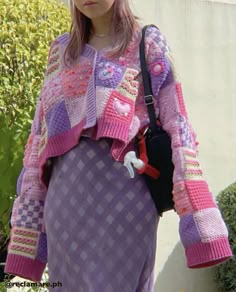 a woman wearing a purple dress and pink sweater