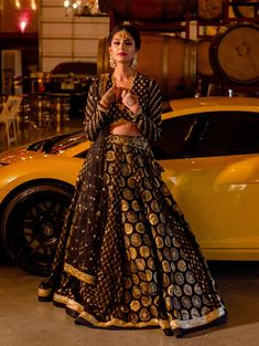 Tamana - Black & Gold Banarasi Brocade Bridal Lehnga Choli with sequins embroidery Look like a goddess in this traditional authentic Banarasi Lengha ensemble and take everyone by storm! V-neck full sleeve choli blouse with zardozi & sequins V-neckline feature that accents your shoulder line as well as adds vertical integrity Glamourous black & gold fabric of authentic Banarasi adds a touch of classiness to this stunning piece Intricate gold zardozi hand embroidery adorned with shimmer sequins that adds an extra glam factor Translucent full sleeve with running embellishments adds an interesting contrast to this custom choli Threaded gold scallop trim at the hemline and neckline of this blouse, giving you a lavish feel Modern back open detail with hook closure adds extra elegance to this set Black Bridal Lehenga, Banarasi Bridal Lehenga, Banarasi Lengha, Panel Lehenga, Net Dupatta Designs, Manpreet Toor, Indian Bridal Couture, Indian Wedding Lehenga, Banarasi Brocade