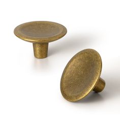 two brass knobs are shown on a white background