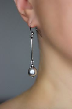 Delicate and simple pearl earrings with high quality gray crystal pearl coated 10 mm beads, silver tone metal sticks, tiny stainless steel bead caps and beads, stainless steel earring hooks. Earring hooks are from nickel free and lead free metal. Perfect for everyday wear or a great gift for someone special! *The total lenght of earrings is about 59 mm including earring hooks. Other earrings of my shop you can see here: https://www.etsy.com/shop/NaTavelli?section_id=13757927 Thanks for visit. Elegant Nickel-free Gray Jewelry, Silver Minimalist Pearl Charm Earrings, Minimalist Silver Pearl Earrings With Charm, Elegant Gray Earrings With Ear Wire, Silver Long Drop Single Pearl Earring, Silver Minimalist Pearl Drop Earrings, Elegant Gray Sterling Silver Earrings, Silver Pearl Minimalist Earrings, Minimalist Silver Pearl Earrings