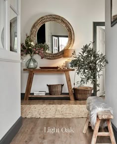 a wooden bench sitting under a round mirror in a living room next to a potted plant