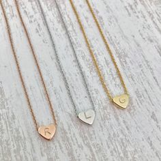 "Dainty Hand Stamped Initial Heart Necklace This hand stamped heart charm necklace makes the perfect gift! Stamp in your kids, grandkids, nieces, nephews, god-child's (or any child!) initials for a one-of-a-kind, keepsake accessory. Be sure to include what initial you would like stamped in the heart charm in the comments section when ordering!! Each heart charm finish will match the finish of the necklace chosen unless otherwise requested Listing for one necklace in Rose Gold, Silver or Gold fin Adjustable Heart Necklace For Mother's Day, Cute Personalized Heart Necklaces, Personalized Heart-shaped Cute Necklace, Cute Heart-shaped Necklaces For Anniversary, Cute Heart Necklaces For Anniversary, Cute Heart Pendant Charm Necklace For Mother's Day, Cute Heart Pendant Charm Necklaces For Mother's Day, Cute Personalized Heart Necklace For Mother's Day, Cute Heart Necklace For Mother's Day Gift