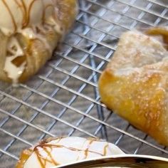 three pastries sitting on a cooling rack with icing and caramel drizzle