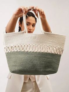 a woman holding up a green and white basket