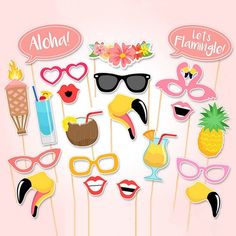 the photo booth is decorated with flamingos, sunglasses and pineapples on sticks