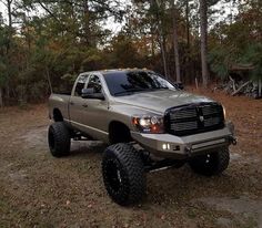 a silver truck parked on top of a dirt road