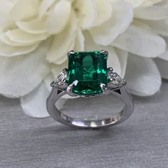 May Birthstone Ring, Emerald Cut Emerald Engagement Ring, Moissanite Ring, Three Stone Ring, Large Cocktail Ring, 14k White Gold Ring, 6722 #EmeraldRing #infinityjewelersusa #WeddingRing #BirthdayGift #EngagementRing #AnniversaryGift #CocktailRing #EmeraldCutEmerald #ThreeStoneRing #MoissaniteRing Three Stone Radiant Cut Ring For Gift, Formal Radiant Cut May Birthstone Ring, Radiant Cut Three Stone Ring Gift, Formal Radiant Cut Ring With May Birthstone, Elegant Tsavorite Gemstones For Anniversary, Radiant Cut Three Stone Ring As A Gift, Emerald Rings With Prong Setting And Round Cut, Radiant Cut Emerald Diamond Ring With Center Stone, Emerald Ring With Prong Setting And Radiant Cut