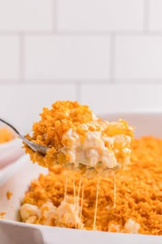 a spoonful of macaroni and cheese being lifted from a casserole dish