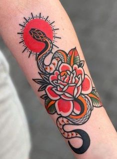 a woman's arm with a flower and snake tattoo on it