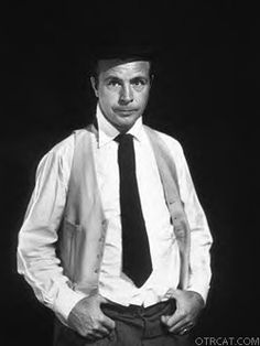 a man in a suit and tie standing with his hands on his hips