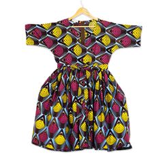 This brightly colored and boldly patterned dress is the original design of Ghana's Lydia Mawuenya Amedzrator. Crafted from 100% cotton in shades of burgundy sky blue and mustard the belted dress features short sleeves a V-neck and full skirt that hits at the knee. Cotton V-neck Dress With Graphic Print, Multicolor A-line Dress With Graphic Print, Vibrant Print V-neck Cotton Dress, Patterned Cotton Dress With Graphic Print, Cotton Graphic Print Patterned Dresses, Vibrant Print Cotton V-neck Dress, Cotton V-neck Dress With Vibrant Print, Multicolor Knee-length Dress With Vibrant Print, Cotton Dresses With Vibrant Patterned Print