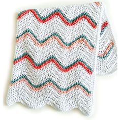 a crocheted dishcloth with red, green and blue stripes on it sitting on a white surface