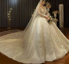 a woman in a wedding dress standing under a chandelier