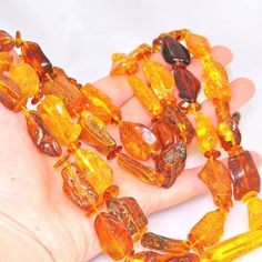 a hand holding some very pretty yellow glass bead necklaces on it's palm