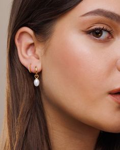 Meet our lovely Lady pearl hoops. Classic, dainty and on trend. These great hoops are here to elevate every outfit. We use freshwater pearls so they could be slight different in shape and tone, we handpick them in our studio so that each pair of earrings will look perfect just for you! * Material : 18K Gold on Brass / Sterling Silver. * Special anti-tarnish protective coating. * Freshwater oval pearl, each pearl is unique and special.  * Comes in beautiful gift packaging. * Comfortable and lightweight.  * Hoop Inner Diameter : 10mm * Pearl Size :  8-10mm * Sold in pairs.  AT CHECKOUT Choose your favorite metal type - 18k gold plated or Sterling Silver.   PACKAGING & GIFTS We will package your order in a beautiful gift box :) * You can also gift the jewelry straight to your loved one!  * If Delicate Teardrop Hoop Earrings, Pearl Drop Dangle Huggie Earrings, Packaging Gifts, Earrings Pearl Drop, Gold Pearl Earrings, Pearl Hoop Earrings, Earrings Pearl, Pearl Size, Pearl Drop Earrings