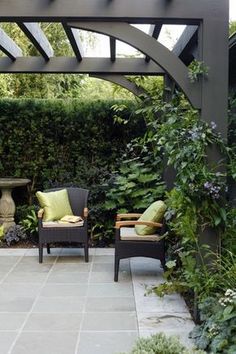 an outdoor patio with two chairs and plants