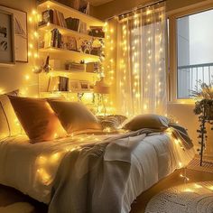 a bed with lights on the headboard and pillows in front of a large window