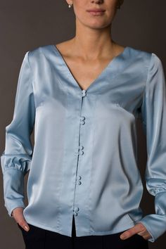 "A beautiful satin blouse featuring button front closure, long sleeves with cuffs, and a v-neckline. - v-neckline - fabric button front closure - long sleeves with cufffs - shift silhouette Color: light blue Fabric: Viscose - 30, polyester - 65%, elastane - 5%. Our model wears size US 8 and is 171cm/5'6\" tall. You may feel free choosing the size. Just send us your measurements (bust, waist, hips, height). We will define your correct size. SIZE CHART XS __ EU 34 __ US 4 bust: 31,5\" | 80 cm wais Satin Button-up Blouse, Spring Satin Blouse With Button Closure, Spring Satin Blouse With Buttons, Satin Blouse With Buttons For Spring, Elegant V-neck Shirt With Button Cuffs, Elegant V-neck Shirt With Buttons, Elegant Long Sleeve Tops With Button Closure, Elegant Satin Tops With Button Cuffs, Elegant Satin Shirt With Buttons