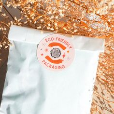 an eco - friendly package sitting on top of some dried flowers