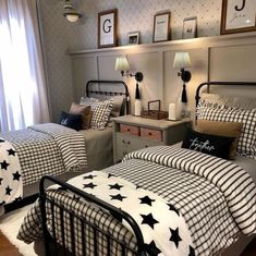 two beds in a bedroom with black and white bedding