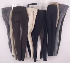 five pairs of women's leggings are lined up on a white surface