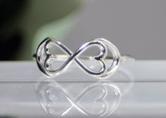 Original and beautiful. This infinity ring has been embellished with two hearts. It is completely sterling silver and a wonderful addition to any wardrobe. Visit my shop for more original items. capturedillusions.etsy.com Sterling Silver Infinity Heart Ring For Wedding, Sterling Silver Infinity Heart Wedding Ring, Handmade Adjustable Elegant Heart Ring, Elegant Handmade Adjustable Heart Ring, Elegant Nickel-free Heart Ring As Gift, Elegant Adjustable Nickel-free Heart Ring, Elegant Nickel-free Heart Ring Gift, Sterling Silver Infinity Ring Gift, Sterling Silver Infinity Ring