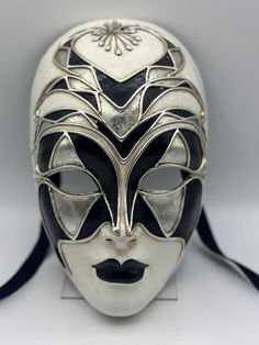 venetian mask full face. Gala mask of a woman face mask, decorated in white, silver and black. This is an intriguing mask with such an expressionless face that it makes you wonder who or what is behind this mask. This face mask would be an intriguing object as wall art, but can most definitely be used for a theater mask, gala mask, masquerade mask.  The mask has straps for wearing. Also a very special Halloween mask. Black Full Face Carnival Masks, Artistic White Masks And Prosthetics For Theater, Artistic White Mask For Theater, Artistic Black Masks And Prosthetics For Mardi Gras, Artistic White Masks And Prosthetics For Mardi Gras, Black Full Face Masks For Carnival, Artistic White Masks For Mardi Gras, White Full Face Mask For Masquerade, White Venetian Mask