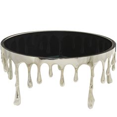 a black and silver coffee table with dripping white paint on the glass top, in front of a white background