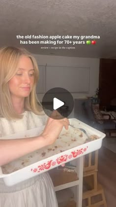 a woman in white dress holding a tray with food on it and texting that reads, the old fashion apple cake my grandma has been making for four years