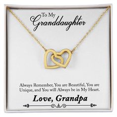 a gold necklace with two intertwined hearts in it