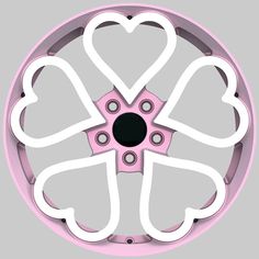 a pink and white circular object with hearts cut out of it's center piece