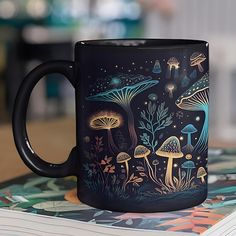 a black coffee mug sitting on top of a table next to a pile of books