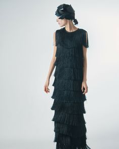 An exquisite and elegant evening dress, crafted from wide rows of fringe, is designed to inspire a truly memorable look. The fringe creates a sophisticated effect of movement and play of light. Thanks to its unique design and attention to detail, it perfectly accentuates your femininity and sophistication. This sleeveless garment, yet covering the shoulders, features a round neckline that adds a touch of charm to the overall look. With a lining for comfort and confidence in movement, it is the p Floor-length Fringe Evening Dress For Gala, Elegant Floor-length Tassel Dresses, Elegant Tasseled Evening Dress, Elegant Floor-length Evening Dress With Fringe, Floor-length Dresses With Tassels For Gala, Floor-length Gala Dresses With Tassels, Fitted Flapper Dress With Tassels For Evening, Fitted Tassel Flapper Dress For Evening, Elegant Fringe Dress For Gala